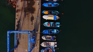 Bulgaristan 'daki rıhtımda çeşitli küçük balıkçı tekneleri dinleniyor. Teknelerin canlı renkleri mavi suyla tezat oluşturuyor. Huzurlu bir liman manzarası sergiliyor..