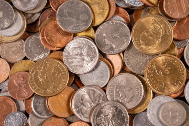 Birçok ülkeden gelen küçük ve büyük paralar düz bir yüzey üzerinde bir araya getirilir. Bozuk paralar farklı renkler, boyutlar ve tasarımlar gösterir, para çeşitliliğini yansıtır.