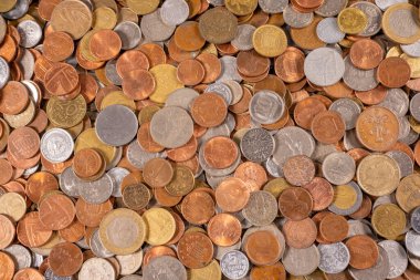 Birçok madeni para düz bir yüzeye saçılmıştır. Farklı şekil ve boyutlar görülebilir. Bazı paralar parlaktır ve diğerleri körelmiştir. Koleksiyon birçok mezhepleri gösterir.