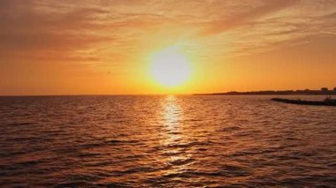 Bulgaristan 'ın Nesebar kentindeki Karadeniz üzerinde güzel bir günbatımı canlı renkler sergiliyor. Sakin sular altın rengini yansıtır gün huzur içinde sona ererken.