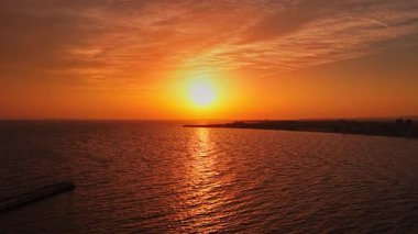 Altın güneş ışığı Karadeniz 'in sakin sularından yansıyarak, Bulgaristan' ın tarihi kıyı kenti Nesebar yakınlarındaki ufukta güzel bir günbatımı manzarası yaratıyor..