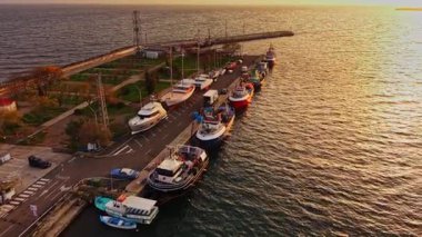 Güneş denizin üzerinde batarken Nesebar limanında dizilmiş balıkçı teknelerinin sakin manzarası sakin su yüzeyinde güzel yansımalar yaratıyor..
