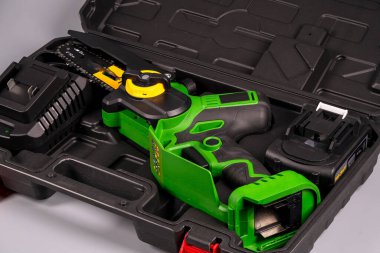 Yeşil bir el bilgisayarı ve ek aksesuarları gösteren kablosuz bir araç seti bir taşıma çantasında gösterilir. Düzenlidir ve ev geliştirme görevleri için hazırdır..