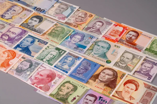 Çeşitli ülkelerden gelen farklı banknotlar gri bir yüzeye yerleştiriliyor. Her nota önemli insanların yüzlerini ve eşsiz tasarımlarını gösteriyor..