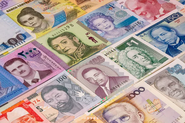 Düz bir yüzeyde farklı ülkelerden gelen çeşitli banknotlar gösteriliyor. Her notta farklı kültürleri ve tarihleri temsil eden eşsiz renkler ve tasarımlar gösteriliyor..