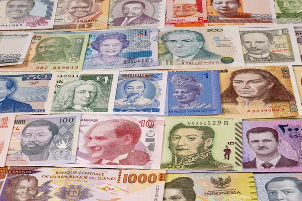 Çeşitli ülkelerden gelen farklı banknotlar masaya serilmiştir. Notlarda her ulustan farklı figür ve semboller gösteriliyor ve para birimi çeşitliliği gösteriliyor.