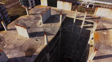 Havadan bakıldığında, çimenli topraklarla çevrili tamamlanmamış bir bina görülüyor. Temeli açıktır, sütunlar ve boş alanlar ortaya çıkar..