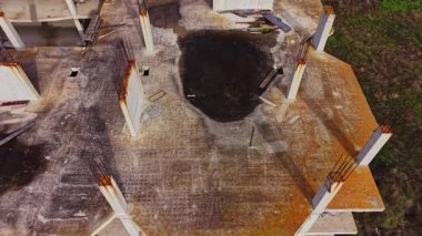 Kısmen inşa edilmiş bir inşaat alanının havadan görüntüsü. Açığa çıkan beton sütunlar ve molozlar devam eden gelişim ve kentsel değişim sahnesi yaratıyor.