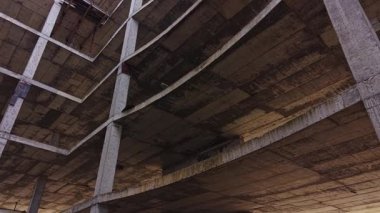 Yukarıdan bakıldığında, beton bir inşaat alanı görülüyor. Ham maddeler, bitmemiş kirişler ve binanın iskeletinin karmaşık tasarımı sergileniyor..