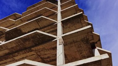 Hava görüntüsü birçok katlı beton bir bina gösteriyor. Yapılandırılmış tasarım yatay ve dikey çizgilere sahiptir. Gökyüzü parlak ve berrak. Görüş mesafesi artıyor..