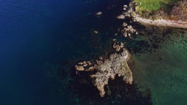 Bu hava manzarası temiz mavi sularla çevrili kayalık bir kıyı şeridini yakalar. Benzersiz kaya oluşumları doğanın güzelliğini gösteren ilginç bir manzara yaratır..
