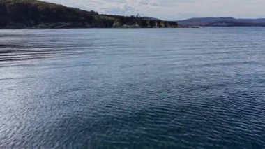 Hava sahneleri gökyüzünü yansıtan sakin sular, uzak kara ve nazik dalgalar doğada barışçıl bir atmosfer yaratıyor..