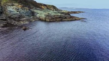 Kayalık oluşumların sakin sularla buluştuğu huzurlu bir sahil manzarası gün boyunca doğanın güzelliğini gözler önüne seriyor..