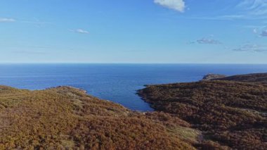 Bu hava sahnesi, mavi suların ve bereketli yuvarlanan tepelerin yer aldığı kıyı bölgesinin nefes kesen manzarasını yakalıyor. Huzur ortamı keşif ve sükuneti davet ediyor..