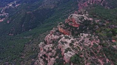 Engebeli arazinin üzerinde, İspanya 'nın kayalıkları yeşil bir vadide kaya oluşumları ve ağaçlar gösteriyor. Dağların geniş bir manzarası bu bölgedeki doğanın güzelliğini gözler önüne seriyor..