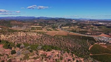 İspanya 'da tepeler boyunca uzanan büyük üzüm bağlarının manzarası. Bu tarım bölgesinde doğa ve altyapının karışımını gösteren yollar ve elektrik hatları görülebilir durumda..