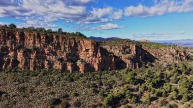 İspanya 'da yeşil ağaçlar ve parlak mavi gökyüzünün altındaki çalılarla çevrili uçurumlar dik bir şekilde yükselir. Güneş doğanın üzerine doğar, kayalık dokuları ve doğal güzellikleri ortaya çıkarır..