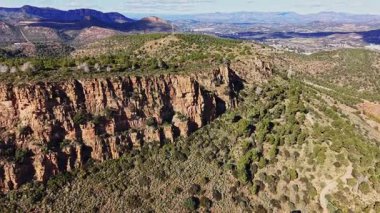 Uçurumlar İspanya 'da engebeli bir manzaranın parçası. Tepeler yeşil çalılar ve ağaçlarla kaplı. Gökyüzü açık, açık hava aktiviteleri için güzel bir gün..