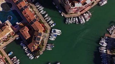 Yukarıdan, İspanya 'daki binalarla çevrili bir marinaya tekneler yanaştı. Su sakin görünüyor, ve bazıları demirli, diğerleri ise denize açılmaya hazır..
