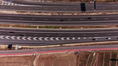 İspanya 'da otoban boyunca uzanır ve arabalar farklı yönlere hareket eder. Tarlalar yol kenarında görülebilir, tarımsal araziler gösterilir..