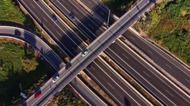 Olay yeri İspanya 'da birkaç şeritli bir otoyol gösteriyor. Araçlar yol boyunca ilerliyor. Kenarlarda yeşil alanlar görülebilir. Bulutsuz açık bir gün..