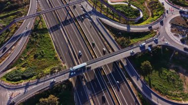 Arabalar İspanya 'da yoğun bir yol sisteminde seyahat ederler. Ayar, trafik farklı yönlere giderken yol etrafında birden fazla şerit, kavşak ve yeşil alanları gösterir.