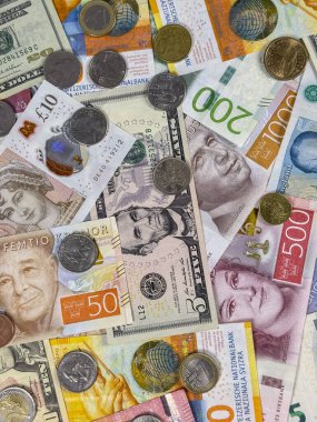 Birçok ülkeden gelen farklı banknotlar ve madeni paralar düz bir yüzeye yerleştirilmiştir. Para birimlerinin renkleri ve tasarımları bir şablon ve şekil karışımı oluşturur.