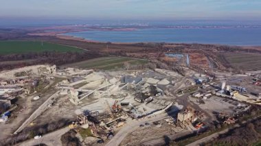 Makinelerin taş kırmada aktif olduğu büyük bir taş ocağı. Site çevresindeki manzaralı bir su kütlesinin yanında yer alıyor..