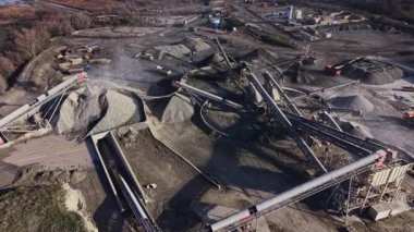 Olay yeri, büyük makinelerin mayınları taşıdığı ve işlediği yoğun bir taş ocağını gösteriyor. Birçok çakıl ve kaya yığını ve taşıma bantlarıyla birlikte iş yerinde görülebilir..