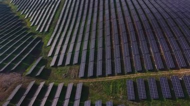 Güneş panelleri geniş bir alan boyunca uzanıyor. Fotoğraf, parlak güneş ışığı altında berrak çizgiler ve gölgelerle güneş çiftliğinin planını gösteriyor..