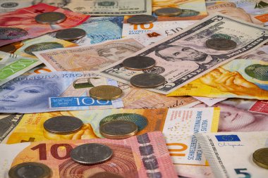 Birçok ülkeden gelen kağıt para ve banknotlar düz bir yüzeye dağılmıştır. Karışımda farklı renk ve boyutlarda notalar ve farklı madeni paraların yanı sıra.