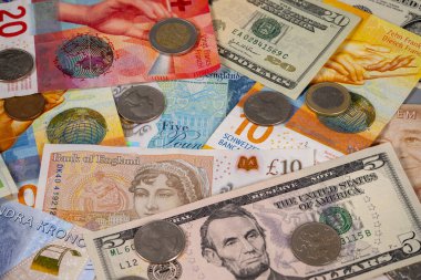 Birçok ülkeden gelen farklı kağıt para ve banknotlar düz bir yüzeye yerleştirilir. Para birimi arasında ABD doları, İsviçre frangı ve İngiliz sterlini yer alıyor..