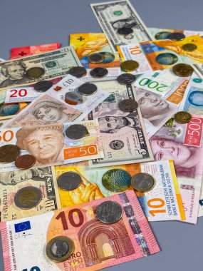 Farklı ülkelerden gelen farklı banknotlar ve madeni paralar düz bir yüzeye serilmiştir. Para, farklı renk ve boyutlarda notların yanı sıra çeşitli madeni paralar da içeriyor..