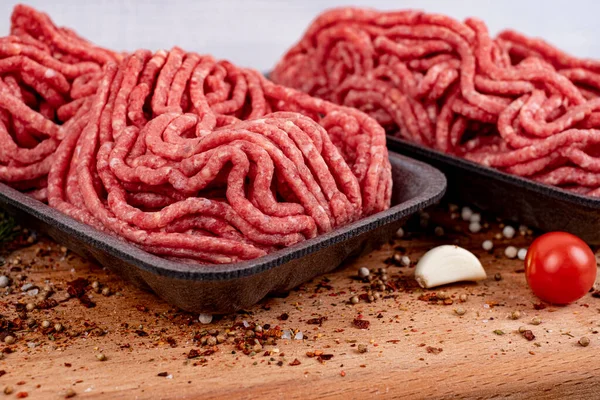 Minced meat in a tray with tomatoes, garlic and pepper