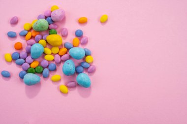 Paskalya yumurtaları ve pembe arka planda renkli tatlılar. 20