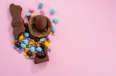 Paskalya yumurtaları ve pembe arka planda renkli tatlılar. 20