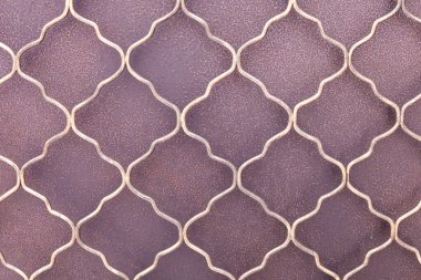 Kavisli metal kalıpları zengin bir arkaplan karşısında çarpıcı geometrik şekiller yaratır. Sıcak renkler, Miruksers sanatının tipik zanaat ve tasarımını ön plana çıkarıyor..