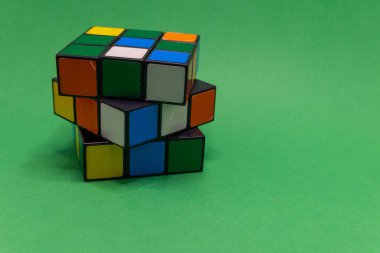 Çırpılmış 3x3 katmanlı bir bulmaca kübü katı yeşil bir zemine dayanır..