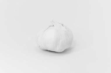 Yiyeceğe tat katmak için popüler bir bileşen olan tek bir sarımsak soğanı, temiz beyaz bir arkaplanda izole edilir..