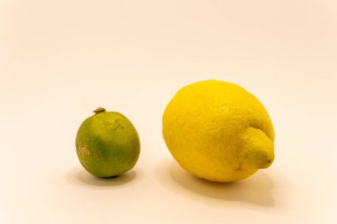 Canlı yeşil bir kireç ve parlak sarı bir limon yan yana yerleştiriliyor, farklı renk ve boyutlarını vurguluyorlar..