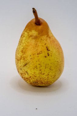 Tek, olgun, sarı-kahverengi bir armut, temiz beyaz bir arkaplanda temiz bir ekran için fotoğraflanmış..