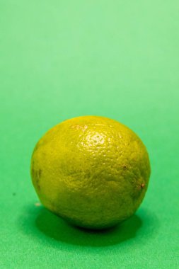Canlı yeşil bir kireç aynı yeşil arkaplanda oturur, her türlü yemek ve içeceğe lezzet katmaya hazırdır..
