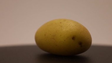 Büyüleyici bir düzende basit bir patates sergiliyor. Dokularını ve renklerini vurguluyor. Odak, günlük güzelliğe ve sanatsal ilhama dikkat çekiyor..