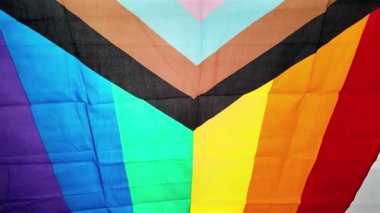 Güneş ışığı altında dalgalanan trans gurur bayrağının yavaş çekimleri rüzgarda mavi, pembe ve beyaz renklerini gösteriyor.. 