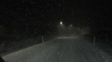 Yavaş çekim iç perspektifi camda eriyen karları, kırılan sokak lambalarını ve zorlu kış koşullarında dönen arabaları gösteriyor.. 