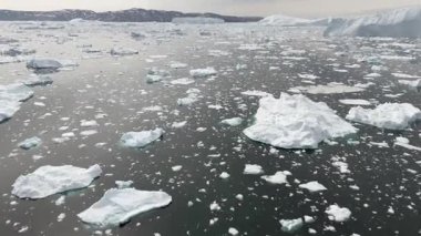 İnsansız hava aracı yükselmeden önce buzdağlarının üzerinden kayar ve kayan buzlarla dolu geniş bir Kuzey Kutbu ufkunu ortaya çıkarır..