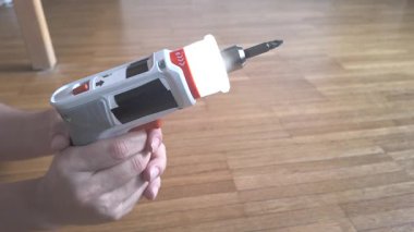 Test çekimi, sağ tarafı çevirirken kablosuz bir tornavidayı havada tutan elleri gösteriyor..