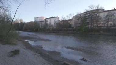 Kamera nehir boyunca ilerler ve açık bahar gökyüzünün altındaki şehir yaşamını gözler önüne serer.