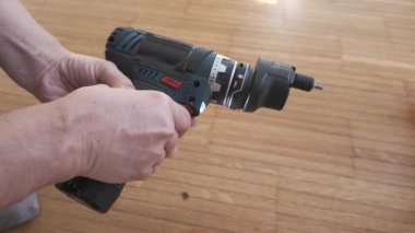 Kablosuz elektrik matkabının sağ tarafını gösteren sıcak açılı çekim, dönen bit ve zemin arka planıyla havada test ediliyor..