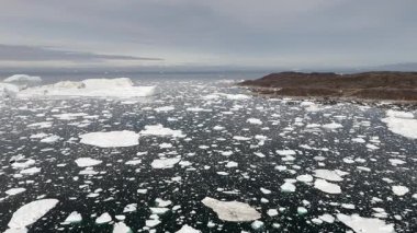 Yüksek irtifa binlerce donmuş parçanın barışçıl bir şekilde yüzdüğünü gösteriyor, ölçeği, izolasyonu ve soğuk kuzey ortamını vurguluyor.